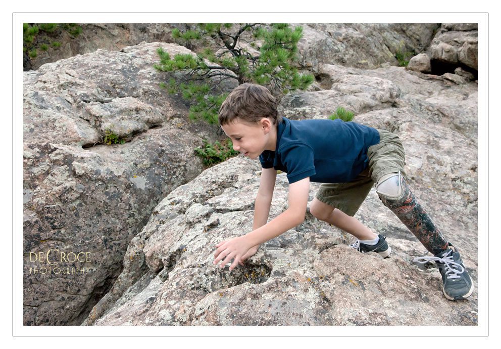 Boy Wears Prosthetic Leg while climbing rocks