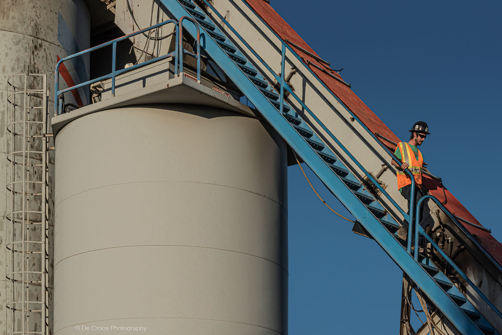 Worker steps and silo commercial industrial photography.